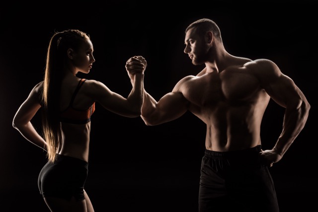Ostarine MK-2866:young sporty couple holding hands isolated on black 